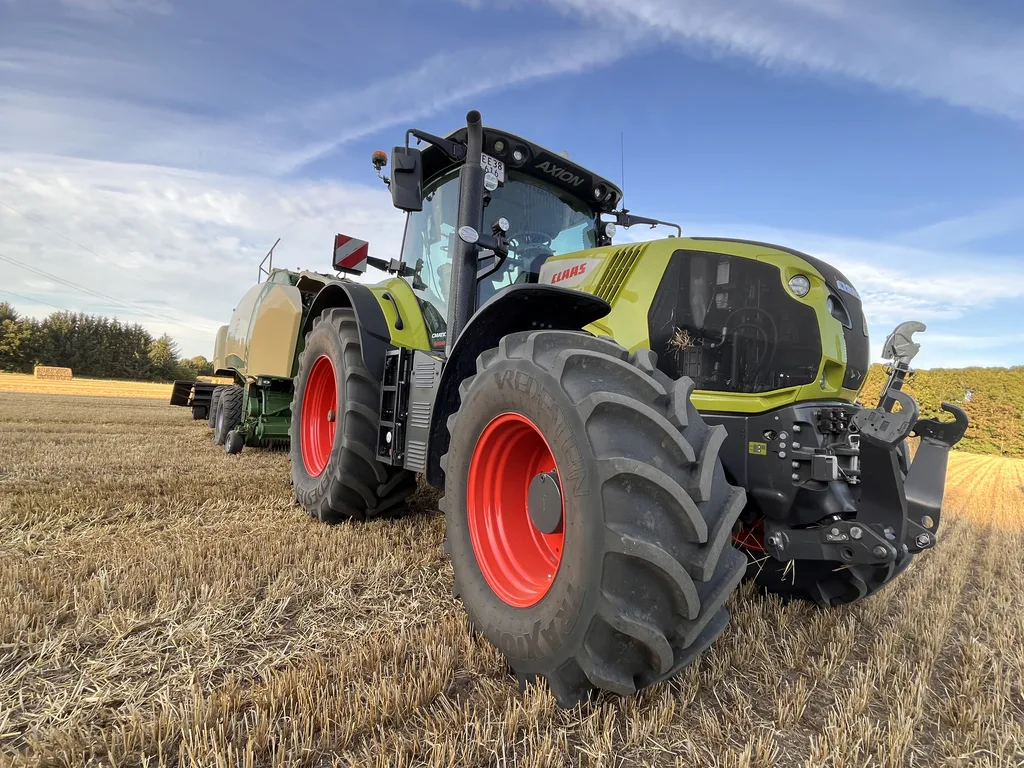 Claas Axion med Krone BiG Pack på stubmarken, set skråt forfra